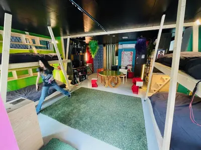 a room with two bunk beds and a person jumping up at Lab8 Tokyo - Creative Coliving & Group Stay 6 Minutes to Shibuya Stay Play & Connect in Tokyo