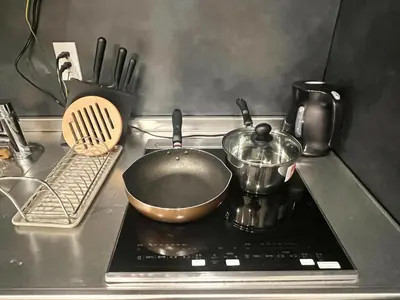 a frying pan on a stove with a pot on it at \u65b0\u5bbf6 Home in Tokyo