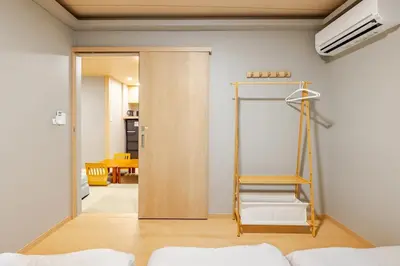 a room with a wooden door and a ladder at \u65b0\u5bbf6 Home in Tokyo