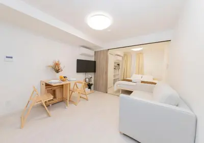 a white living room with a white couch and a table at FL Residence Shinjuku Gyoen V in Tokyo
