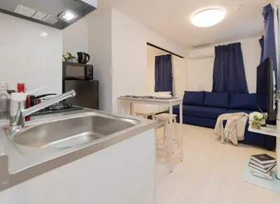 a kitchen with a sink and a blue couch at FL Residence Shinjuku Gyoen V in Tokyo