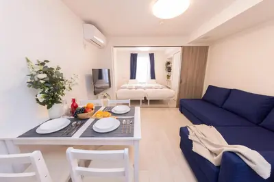 a living room with a blue couch and a table at FL Residence Shinjuku Gyoen V in Tokyo