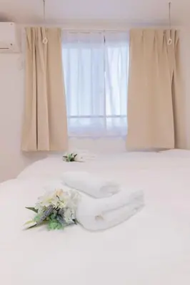 a wedding dress and flowers on a bed at FL Residence Shinjuku Gyoen V in Tokyo