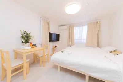 a bedroom with a bed and a table and a desk at FL Residence Shinjuku Gyoen V in Tokyo
