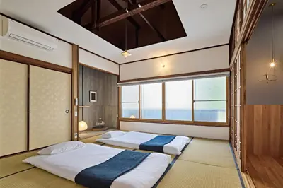 two beds in a room with two windows at Pufuka Wakakusa \u3077\u3075\u304b\u82e5\u8349 in Tokyo