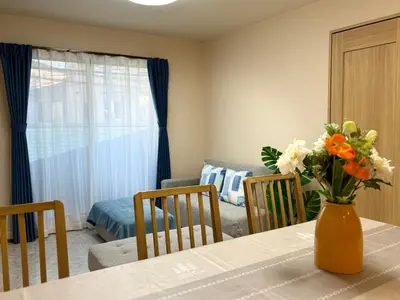a dining room table with a vase of flowers on it at Lapis House 201 - 2F & 3F in Tokyo