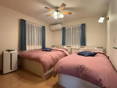 a bedroom with two beds and a ceiling fan at Lapis House 201 - 2F & 3F in Tokyo