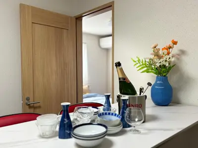 a table with a bottle of wine and a vase of flowers at Lapis House 201 - 2F & 3F in Tokyo