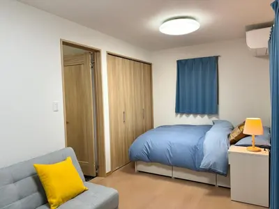a bedroom with a blue bed and a couch at Lapis House 201 - 2F & 3F in Tokyo