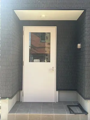 a white door in a room with a brick wall at DainHostel2 in Tokyo