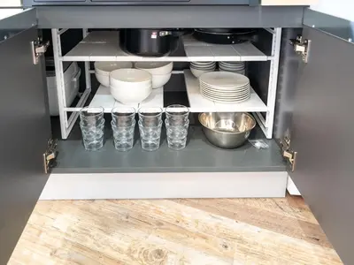 a kitchen pantry with dishes and cups on a shelf at Familia Heiwajima in Tokyo