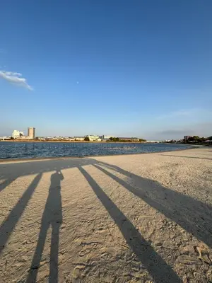 a shadow of a person flying a kite on the beach at Familia Heiwajima in Tokyo