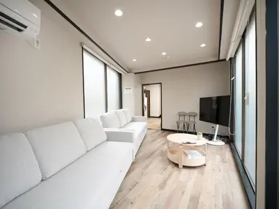 a living room with a white couch and a tv at Familia Heiwajima in Tokyo