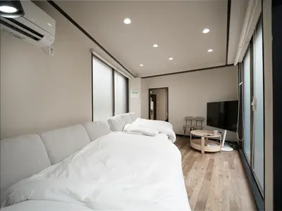 a bedroom with a white bed and a flat screen tv at Familia Heiwajima in Tokyo
