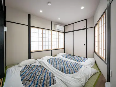 two beds in a room with two windows at Familia Heiwajima in Tokyo
