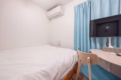 a bedroom with a bed and a desk with a television at \u30b8\u30a7\u30df\u30cb\u30b9\u6c60\u888b303 in Tokyo