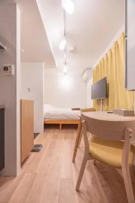 a living room with a table and a bed at \u30b8\u30a7\u30df\u30cb\u30b9\u6c60\u888b203 in Tokyo