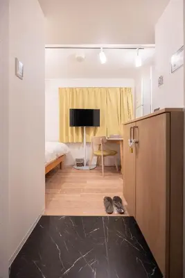 a room with a bed and a desk with a television at \u30b8\u30a7\u30df\u30cb\u30b9\u6c60\u888b203 in Tokyo