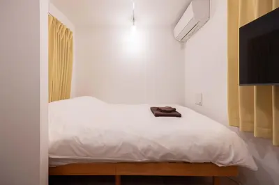 a bedroom with a white bed and a television at \u30b8\u30a7\u30df\u30cb\u30b9\u6c60\u888b203 in Tokyo