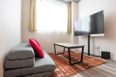 a living room with a couch and a flat screen tv at ARUCiA\u99d2\u6ca2\u5927\u5b66 in Tokyo