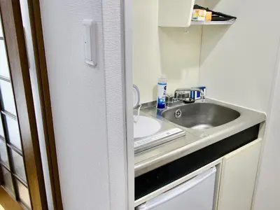 a small kitchen with a sink and a sinkiterator at Garden Otsuka302 -\u30ac\u30fc\u30c7\u30f3\u5927\u585a- \u5927\u585a\u99c5\u5f92\u6b693\u5206 JR\u6cbf\u7dda\u3067\u6c60\u888b\u307e\u30677\u5206 \u7121\u6599Wi-Fi\u3068\u30a2\u30e1\u30cb\u30c6\u30a3\u63d0\u4f9b in Tokyo