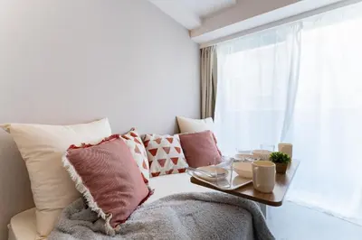 a bedroom with a bed with pillows and a table at Galicia Otsuka in Tokyo