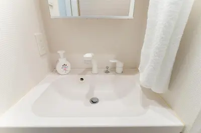 a white sink in a bathroom with a window at Galicia Otsuka in Tokyo