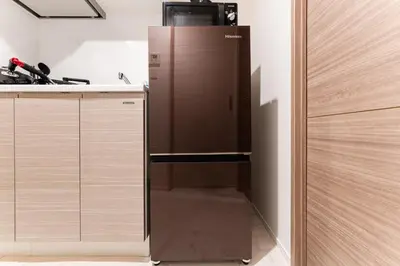 a refrigerator in a kitchen next to a counter at Galicia Otsuka in Tokyo