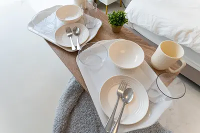 a table with plates and glasses on a bed at Galicia Otsuka in Tokyo