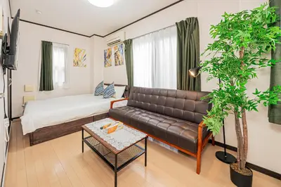 a living room with a couch and a bed at Japan House Oshiage in Tokyo