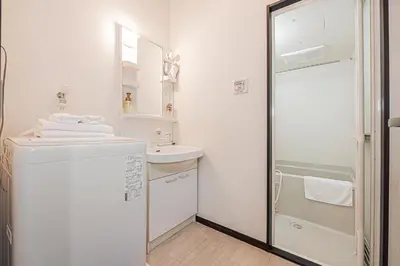 a white bathroom with a sink and a shower at Japan House Oshiage in Tokyo