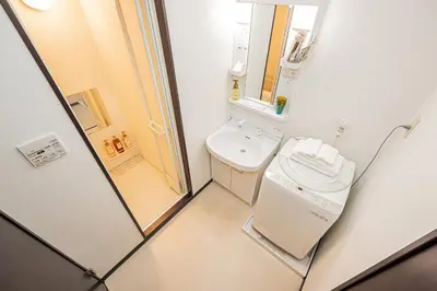 a small bathroom with a toilet and a sink at Japan House Oshiage in Tokyo
