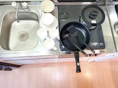 a kitchen counter with a frying pan and a sink at Japan House Oshiage in Tokyo