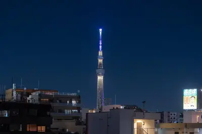 a tv tower is lit up in the city at night at \u7cf8\u3068365\u65e5 in Tokyo