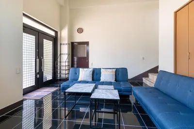a living room with a blue couch and tables at Villa Katsushika\u304a\u82b1\u8336\u5c4b\u99c5\u5f92\u6b6910\u5206 in Tokyo