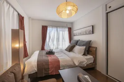 a bedroom with a large bed with a window at Ryusen Panda Hotel Noda in Tokyo