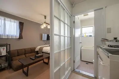 a living room with a couch and a bathroom at Ryusen Panda Hotel Noda in Tokyo