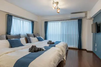 two large beds in a room with large windows at Ryusen Panda Hotel Noda in Tokyo