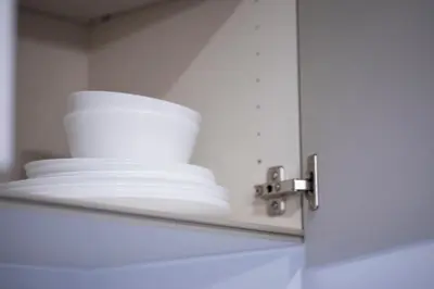 a stack of white plates on a shelf at Ryusen Panda Hotel Noda in Tokyo