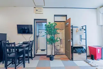 a dining room with a table and a potted plant at Ryusen Panda Hotel Noda in Tokyo