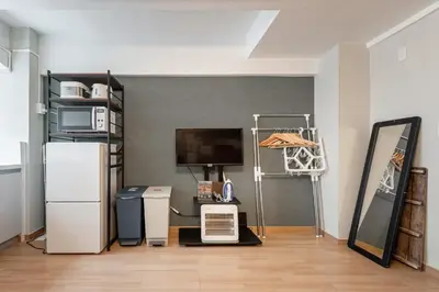 a living room with a refrigerator and a tv at Ryusen Panda Hotel Noda in Tokyo