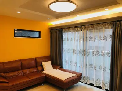a living room with a couch and a window at JL \u6771\u4eac House - \u99d0\u8eca\u5834\u4ed8\u304d\u7bc9\u6d45\u306e\u307e\u308b\u3054\u3068\u8cb8\u5207\u4f4f\u5b85 in Tokyo
