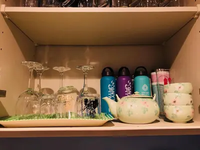 a shelf with glasses and china on it at JL \u6771\u4eac House - \u99d0\u8eca\u5834\u4ed8\u304d\u7bc9\u6d45\u306e\u307e\u308b\u3054\u3068\u8cb8\u5207\u4f4f\u5b85 in Tokyo
