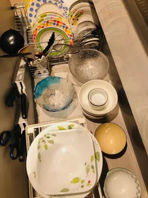 a counter with plates and bowls in a sink at JL \u6771\u4eac House - \u99d0\u8eca\u5834\u4ed8\u304d\u7bc9\u6d45\u306e\u307e\u308b\u3054\u3068\u8cb8\u5207\u4f4f\u5b85 in Tokyo