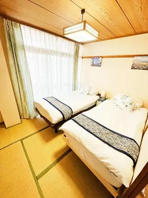 two beds in a room with a window at \u30e1\u30be\u30f3\u30c9\u30ea\u30d0\u30fc\u30b8\u30e5205 in Tokyo