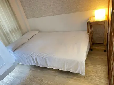 a bedroom with a white bed and a night stand at Nishi-shinjuku-ZYZ SJ0237 in Tokyo