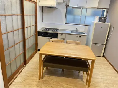 a small kitchen with a table and a refrigerator at Nishi-shinjuku-ZYZ SJ0237 in Tokyo