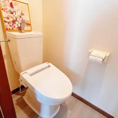a bathroom with a toilet with a picture on the wall at Lucky House\u65b0\u5bbf11 in Tokyo