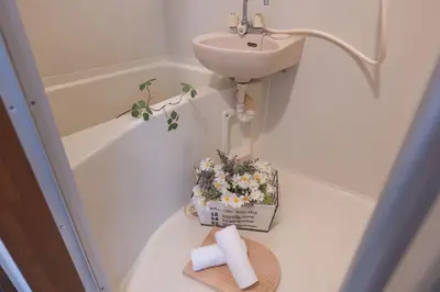 a bathroom with a sink and a flower arrangement at Lucky House\u65b0\u5bbf11 in Tokyo
