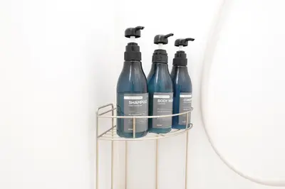a rack with three bottles of water in front of a mirror at \u548c\u306e\u6953cottage\u7b2c\u4e8c302 \u65b0\u5bbf\u6b4c\u821e\u4f0e\u753a\u8fd1\u96a3 in Tokyo